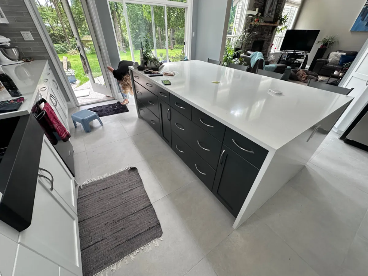 New Anmore kitchen island from above showing dark base cabinets and white quartz waterfall countertop